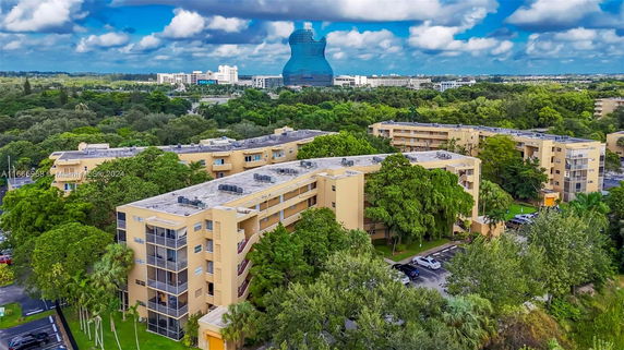 View of multiple residential buildings surrounded by trees with a distinctive guitar-shaped building in the background.