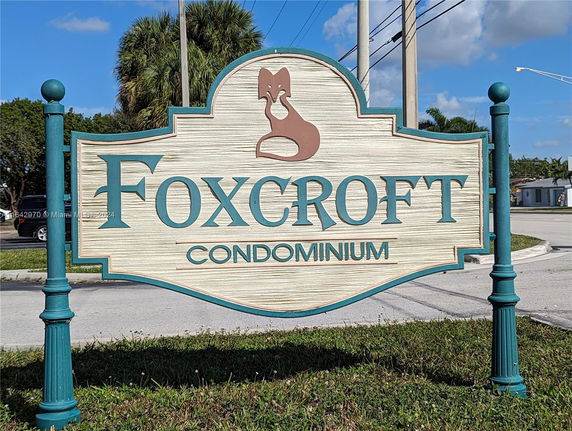 Sign for Foxcroft Condominium on a grassy roadside.