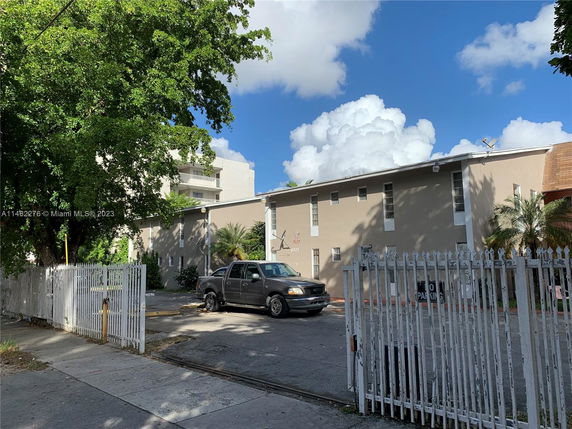 Front view of a two-story building with a gated entrance.