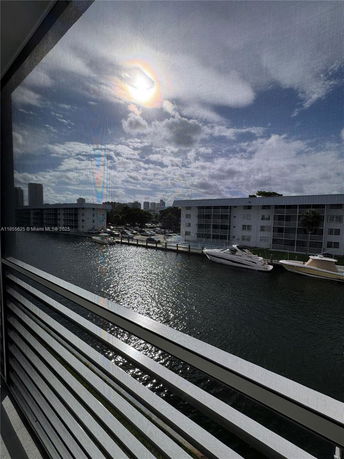 View of waterfront buildings and boats under a cloudy sky from a high vantage point.