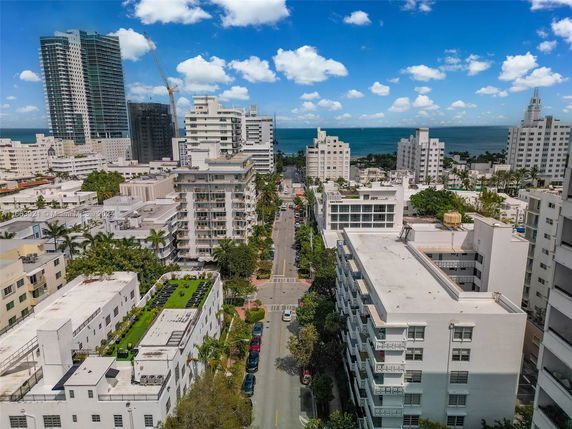 Aerial view of a coastal cityscape with high-rise buildings and ocean in the background.