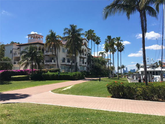 Front view of a multi-story building with balconies and Mediterranean-style architecture.
