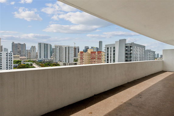 View from a balcony overlooking a cityscape with high-rise buildings.