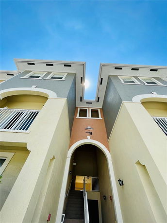 Front view of a multi-story building with arched entrance and balconies.