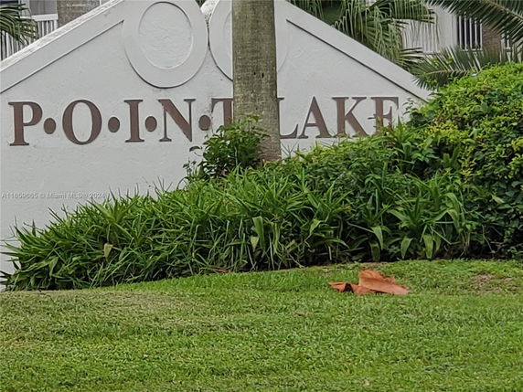 Outdoor sign with the text 'P.O.I.N.T L.A.K.E' surrounded by greenery.