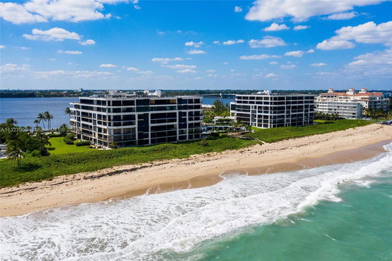 Aerial view of two modern beachfront condominium buildings overlooking the ocean.