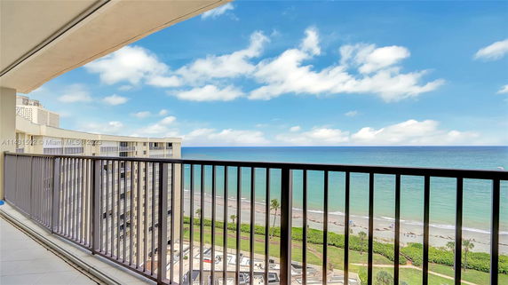View from a balcony overlooking a beach and ocean.
