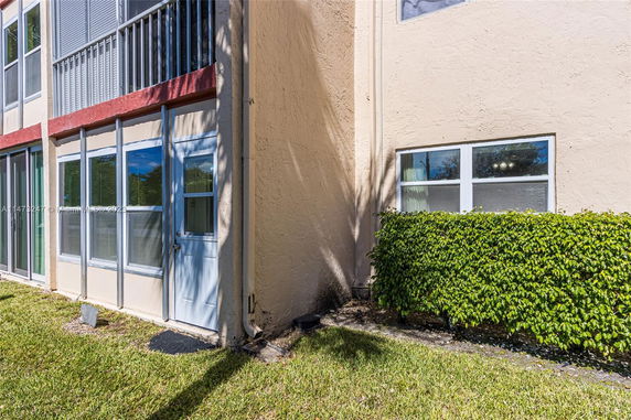 Exterior view of a building with beige walls and multiple windows.
