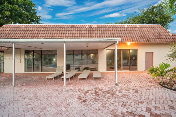 Front view of a house with a patio area and tiled roof.
