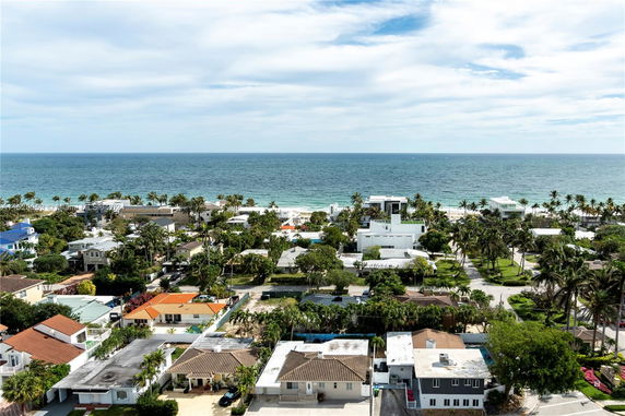 Panoramic view of a coastal residential area with houses and the ocean in the background.