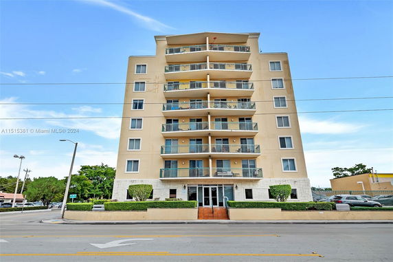 Front view of a multi-story apartment building with balconies.