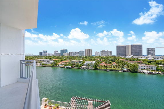 Panoramic view from a balcony overlooking water and cityscape in the distance.