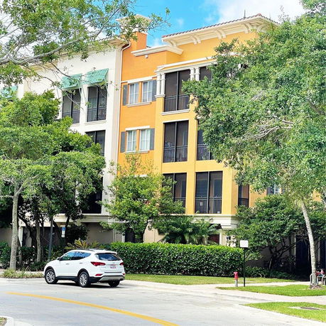 Front view of a multi-story apartment building with orange and white exteriors.