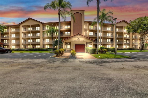 Front view of a multi-story residential building with balconies and an entrance area.