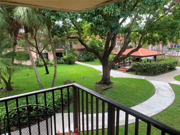 View of a landscaped area with pathways and a gazebo seen from a balcony.