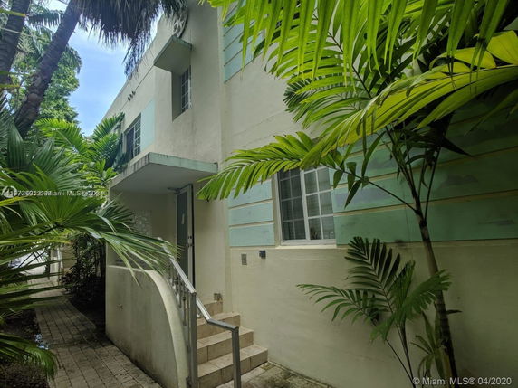 Entrance view of a two-story building with greenery.