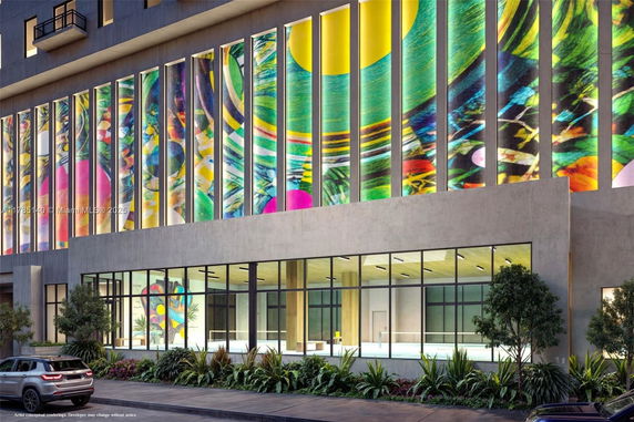 Colorful facade of a multi-story building with large vertical windows.