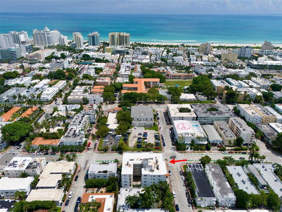 Aerial view of a coastal urban area with multiple buildings and a beach in the background.