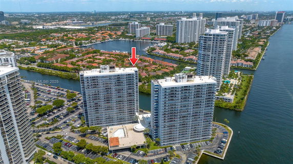 Aerial view of high-rise buildings with surrounding residential areas and water bodies.
