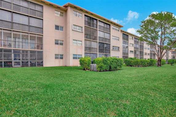 Front view of a multi-story apartment building with screened balconies.