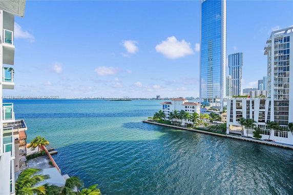 View of a waterfront with high-rise buildings and a wide expanse of water.