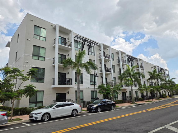 Front view of a multi-story apartment building with balconies.