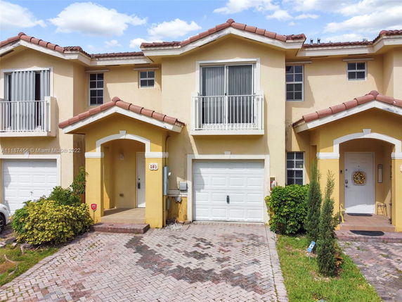 Front view of a two-story house with a garage and balcony.