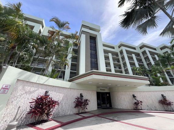 Front view of a multi-story building with a central entrance and balconies.