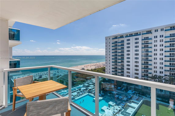 Panoramic view from a balcony showing the ocean and distant beach.