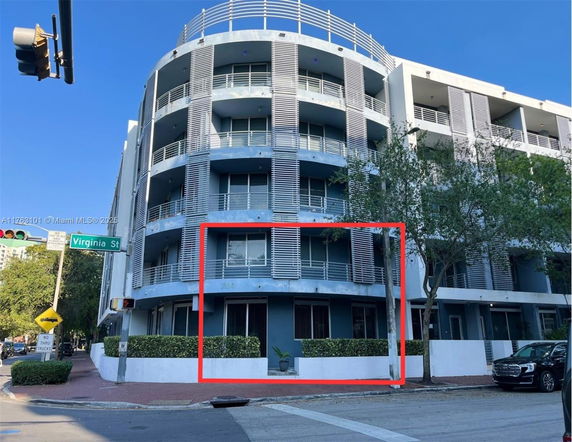Front view of a modern multi-story building with balconies and vertical slats.