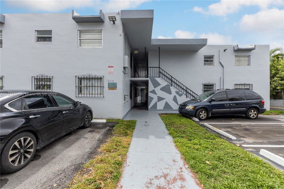 Outdoor parking area in front of a two-story building.