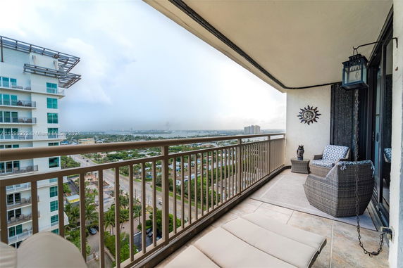 Balcony view showing surrounding cityscape and distant buildings.