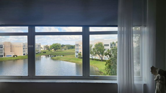 View from a window overlooking a water body and multiple residential buildings in the background.