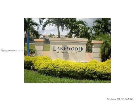 Signage for Lakewood at Emerald Hills surrounded by greenery and palm trees.