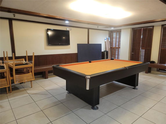 Indoor recreation area with a pool table and seating.