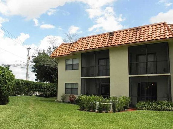 Front view of a two-story building with a red-tiled roof and balconies.