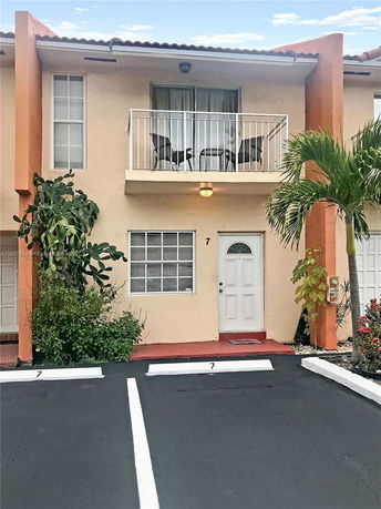 Front view of a two-story townhouse with a balcony.