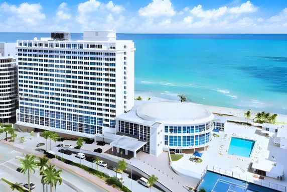 View of a large beachfront hotel with a swimming pool and tennis court.