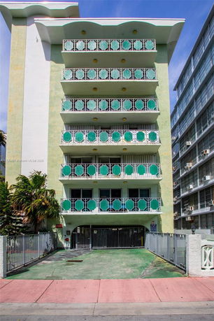 Front view of a multi-story building with decorative balconies.