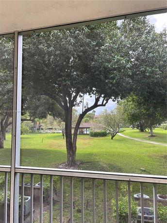 View of a park area with trees and a pathway from a building.