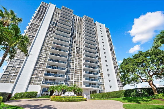 Front view of a high-rise residential building with multiple balconies.