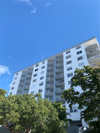 Front view of a multi-story residential building with balconies.