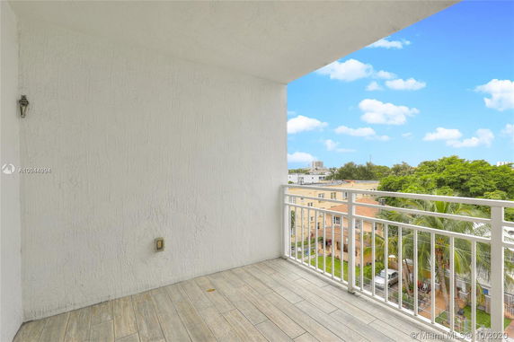 View from a balcony showing surrounding buildings and trees.