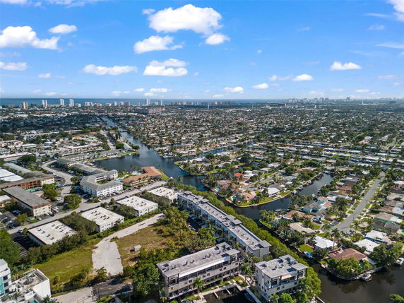 Panoramic view of a city with residential and commercial buildings, roads, and waterways.