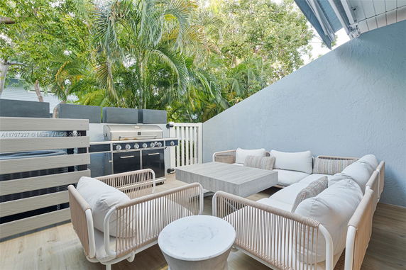 Outdoor patio area with seating and a grill.