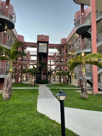 Front view of a multi-story building with external spiral staircases and a courtyard.