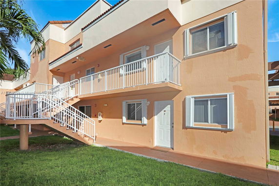 Front view of a multi-story building with external staircases and balconies.