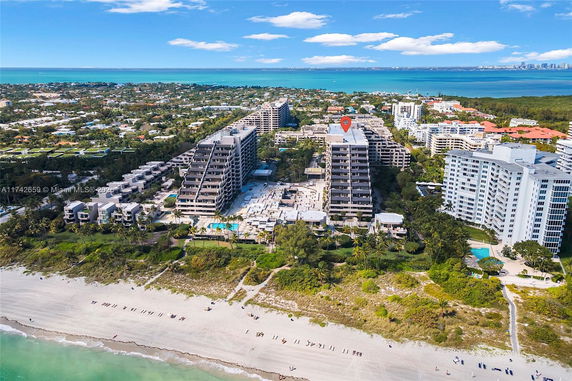 Aerial view of a beachfront condominium complex with multiple high-rise buildings overlooking the beach and ocean.