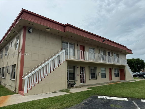 Front view of a two-story apartment building with exterior staircases.