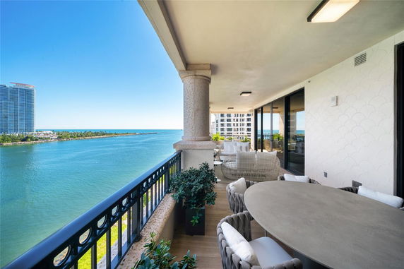 Balcony view overlooking a body of water with high-rise buildings nearby.